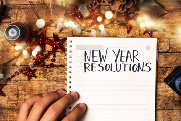 Person writing new year resolutions first person view